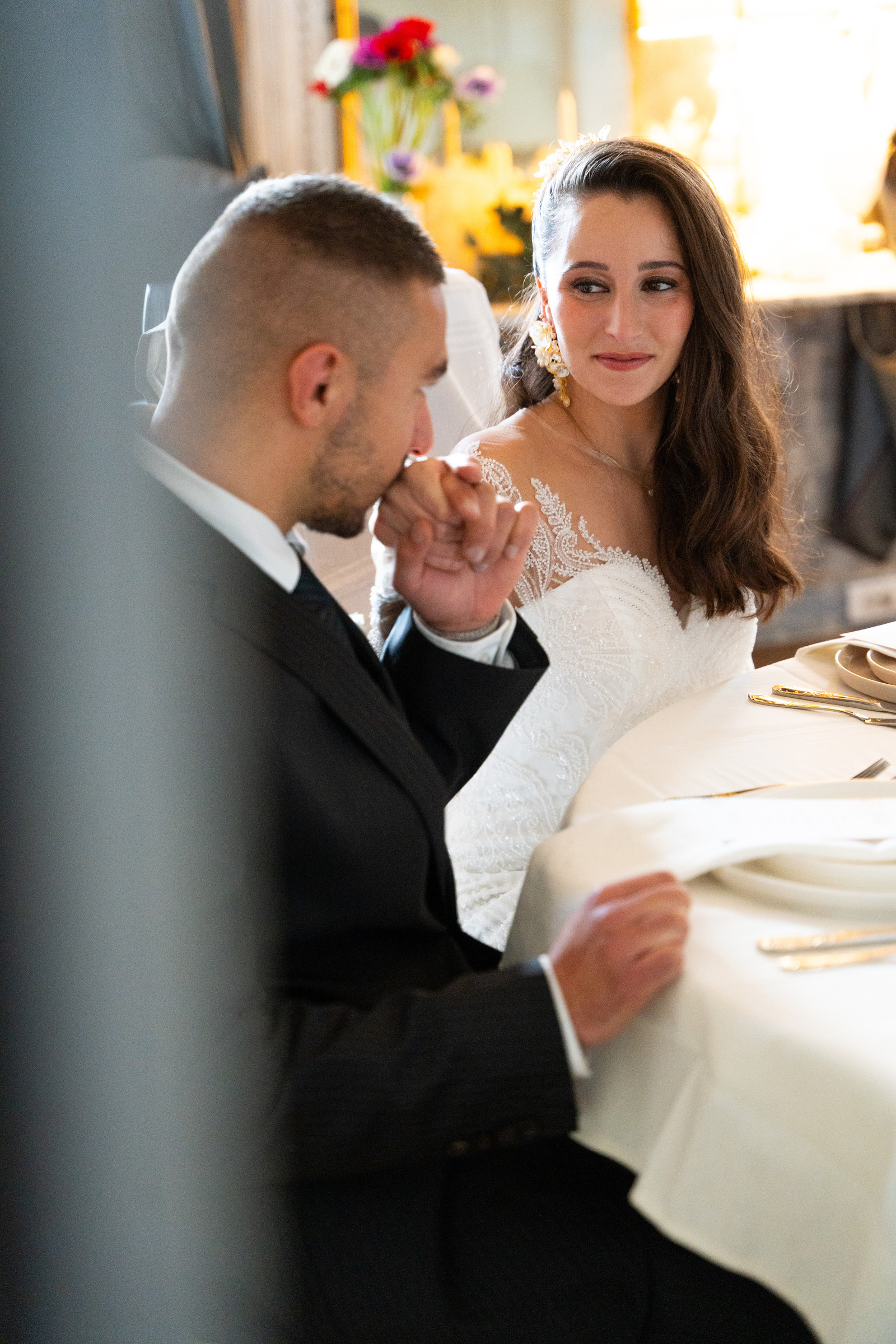 Un couple en tenue de mariage partage un moment à table