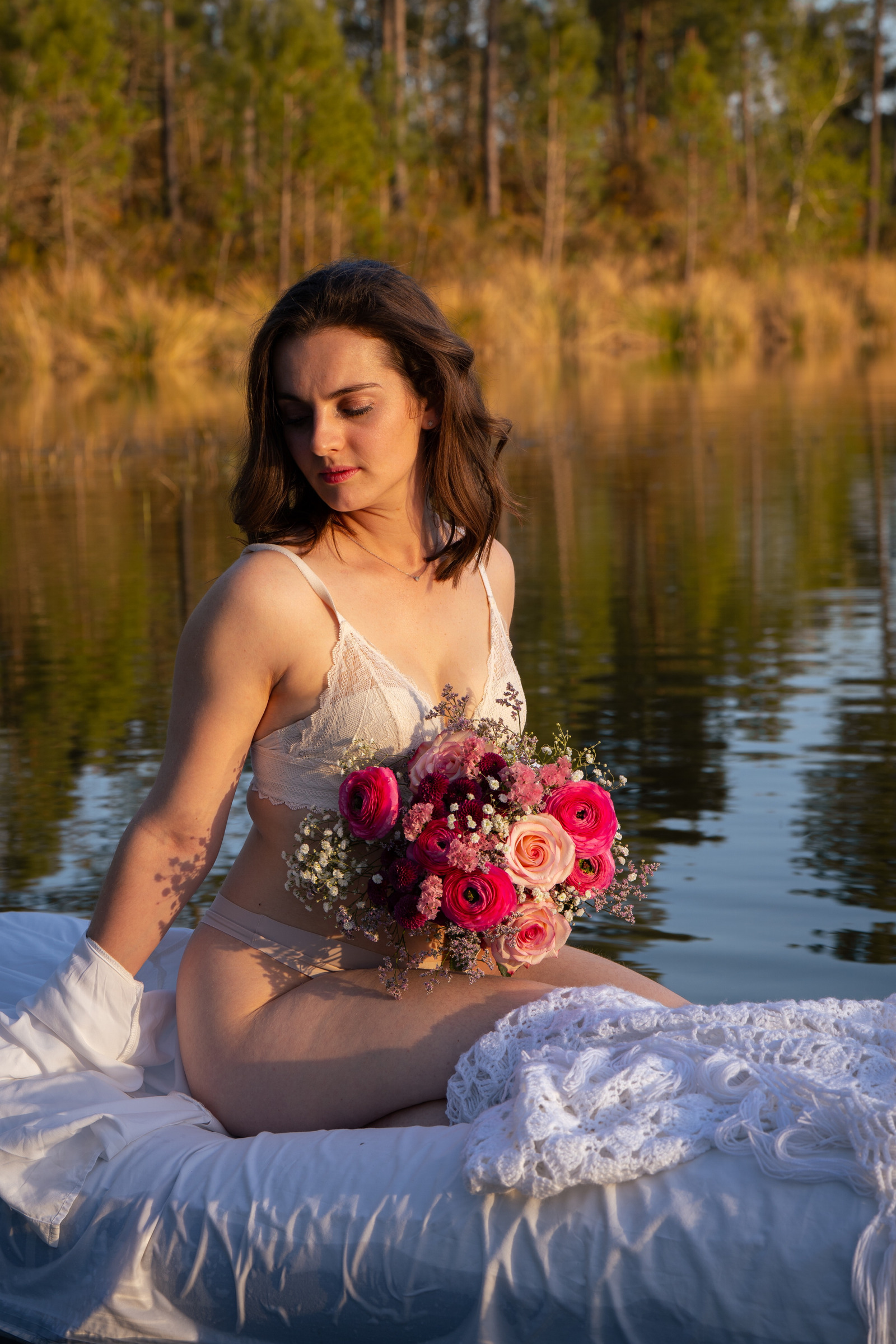 Portrait avec un bouquet rose au bord de l’eau