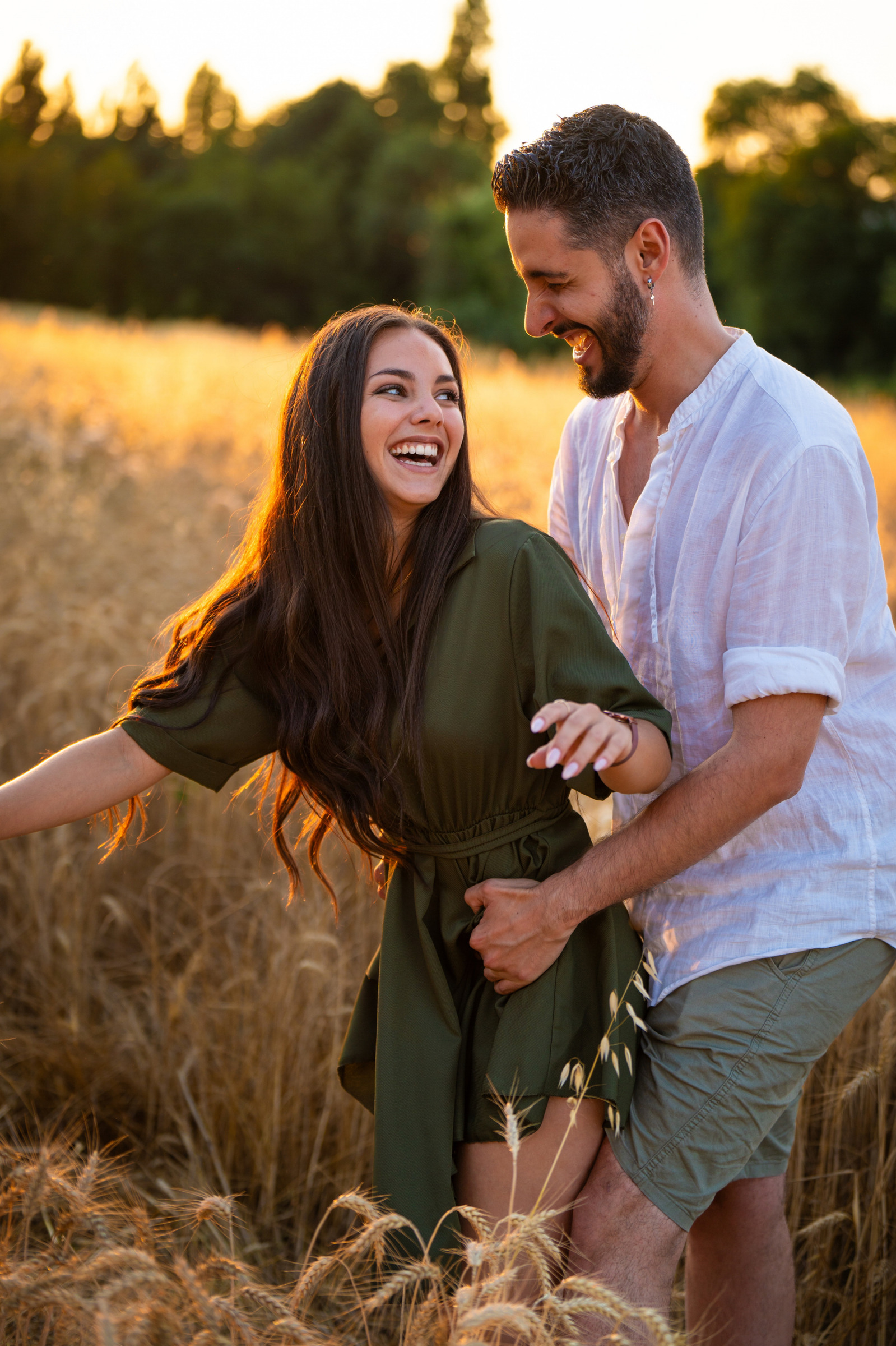 Un couple rit dans les herbes hautes au soleil