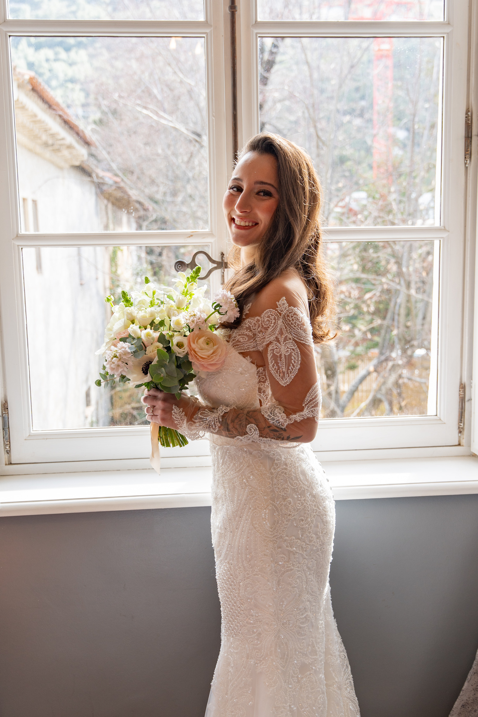 Portrait de mariée au bouquet près d’une fenêtre