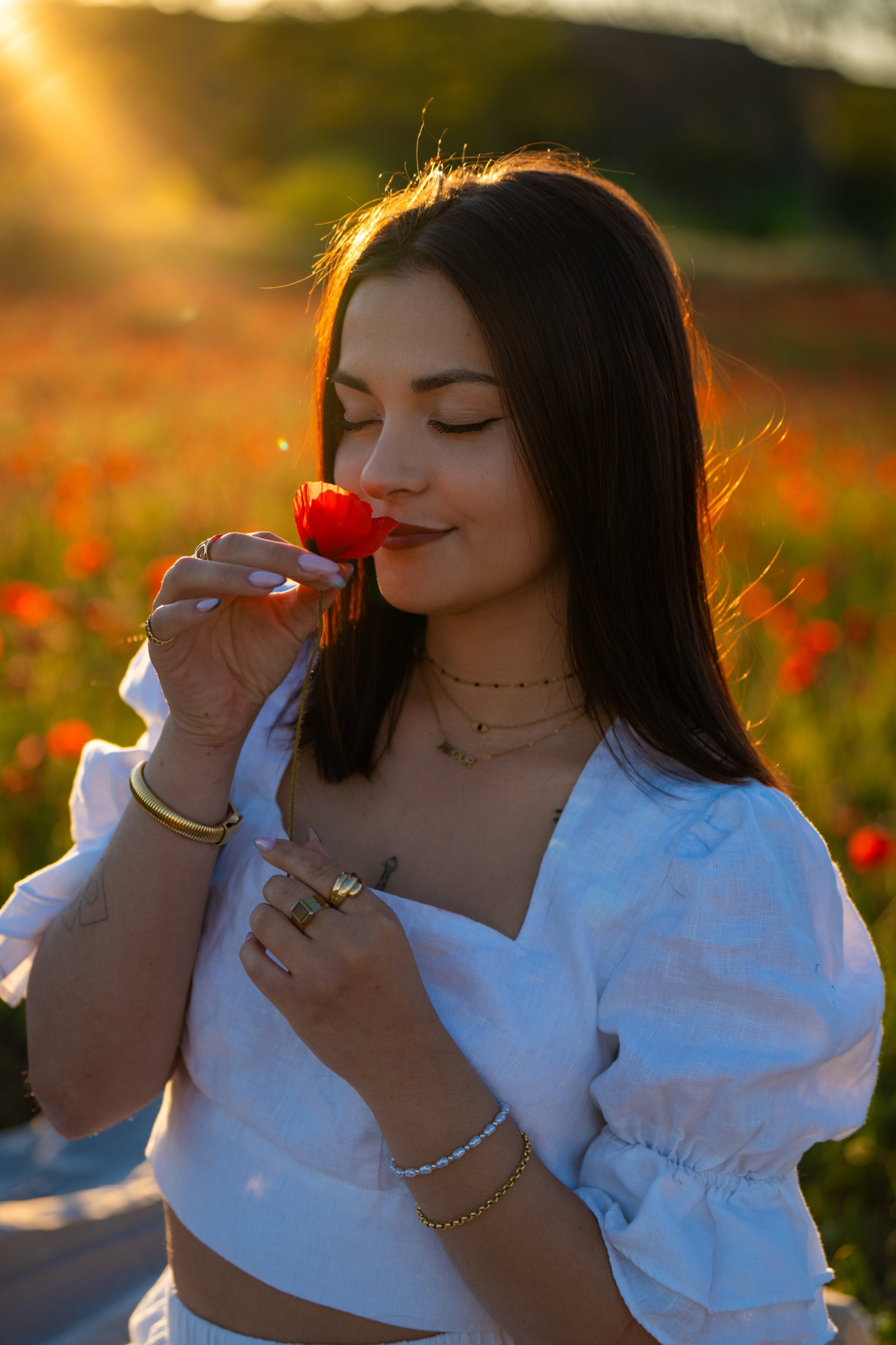 Portrait en blanc avec un coquelicot dans la lumière dorée