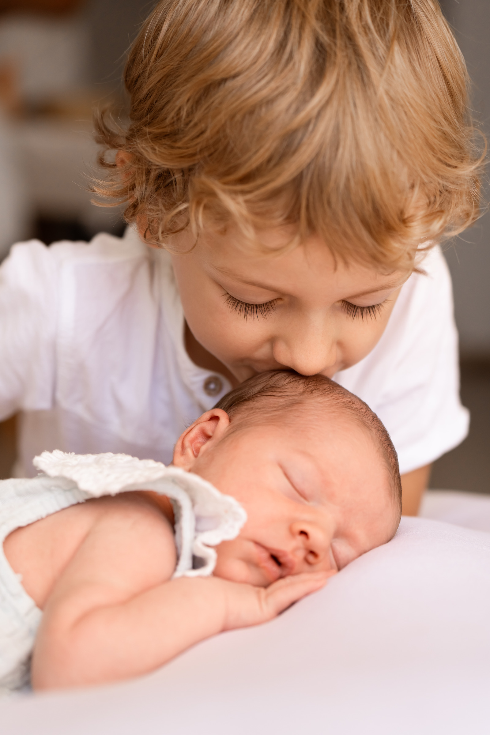 Un enfant embrasse un nouveau-né