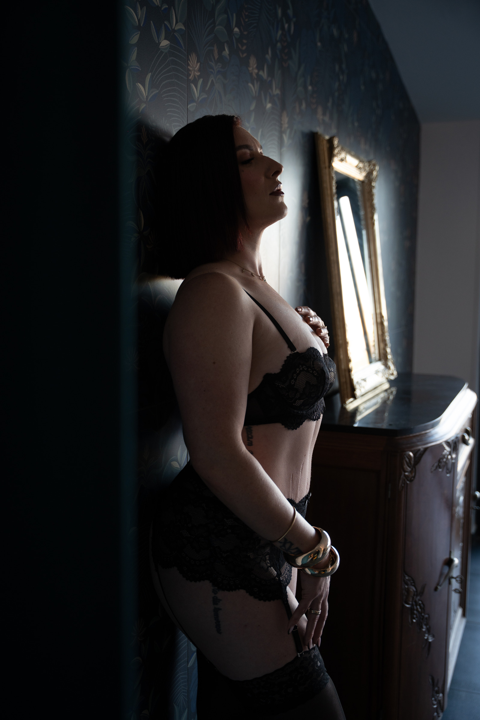 Portrait boudoir en lingerie noire près d’une fenêtre