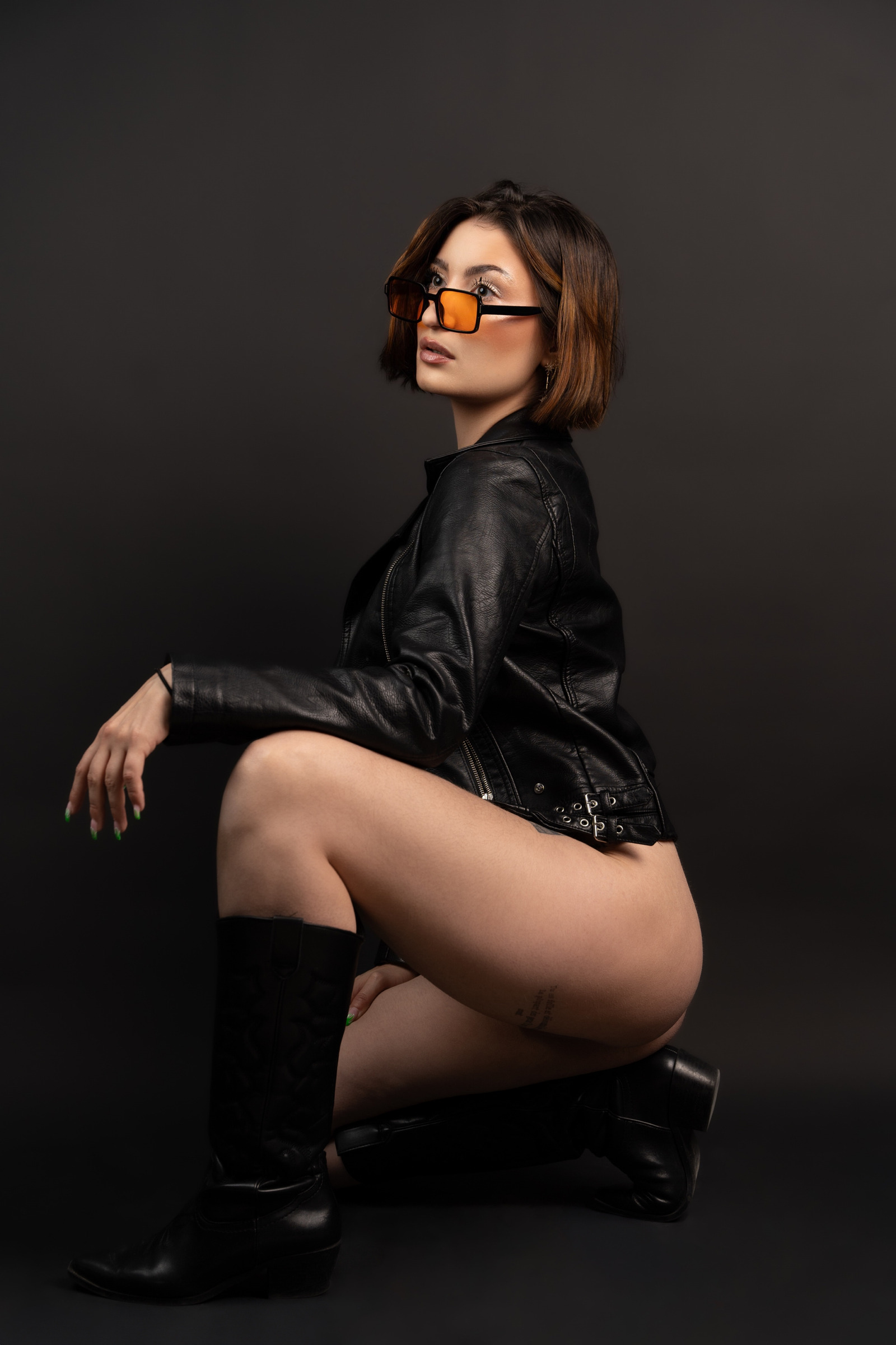 Portrait de mode assis, veste noire et lunettes