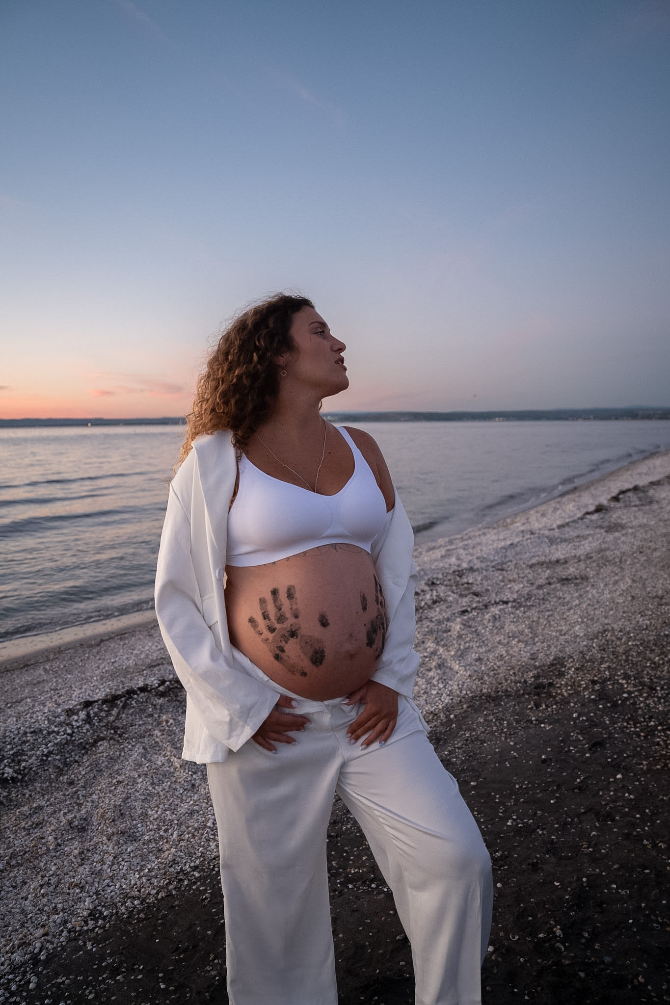 Portrait de grossesse en blanc au bord de la mer
