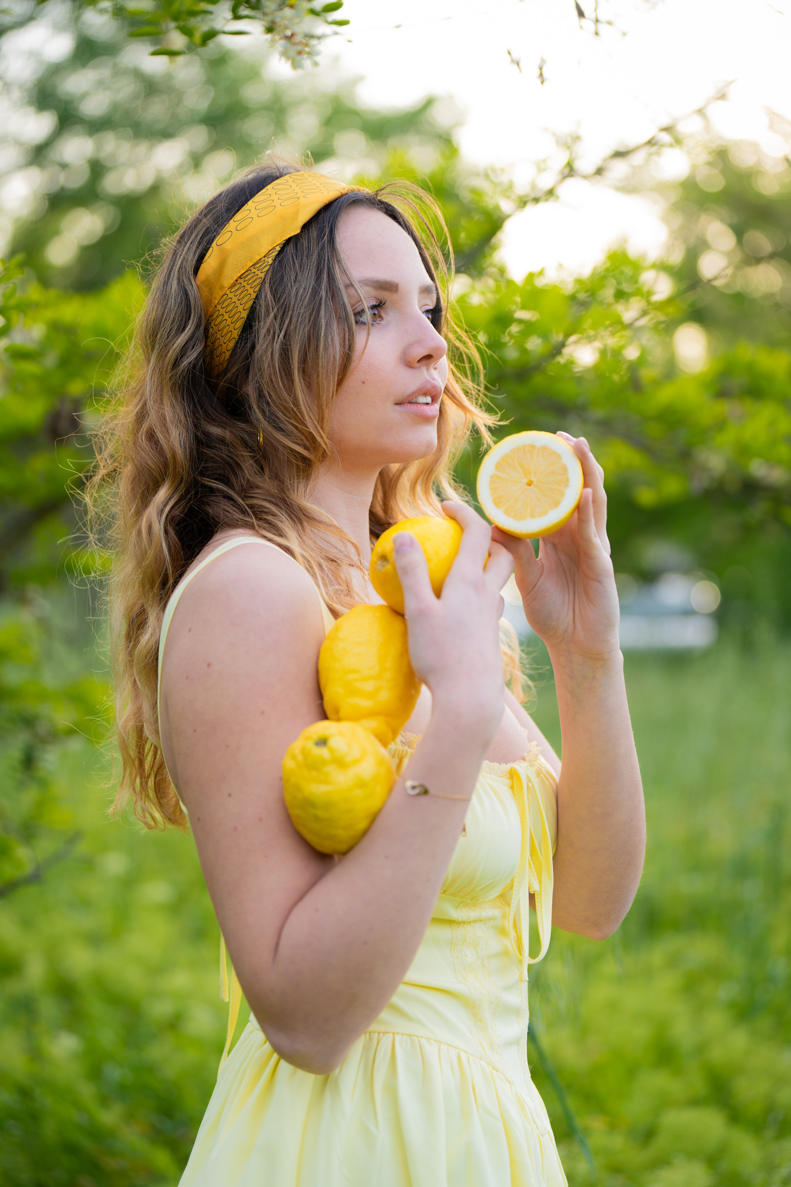 Portrait en robe jaune avec des citrons dans un jardin