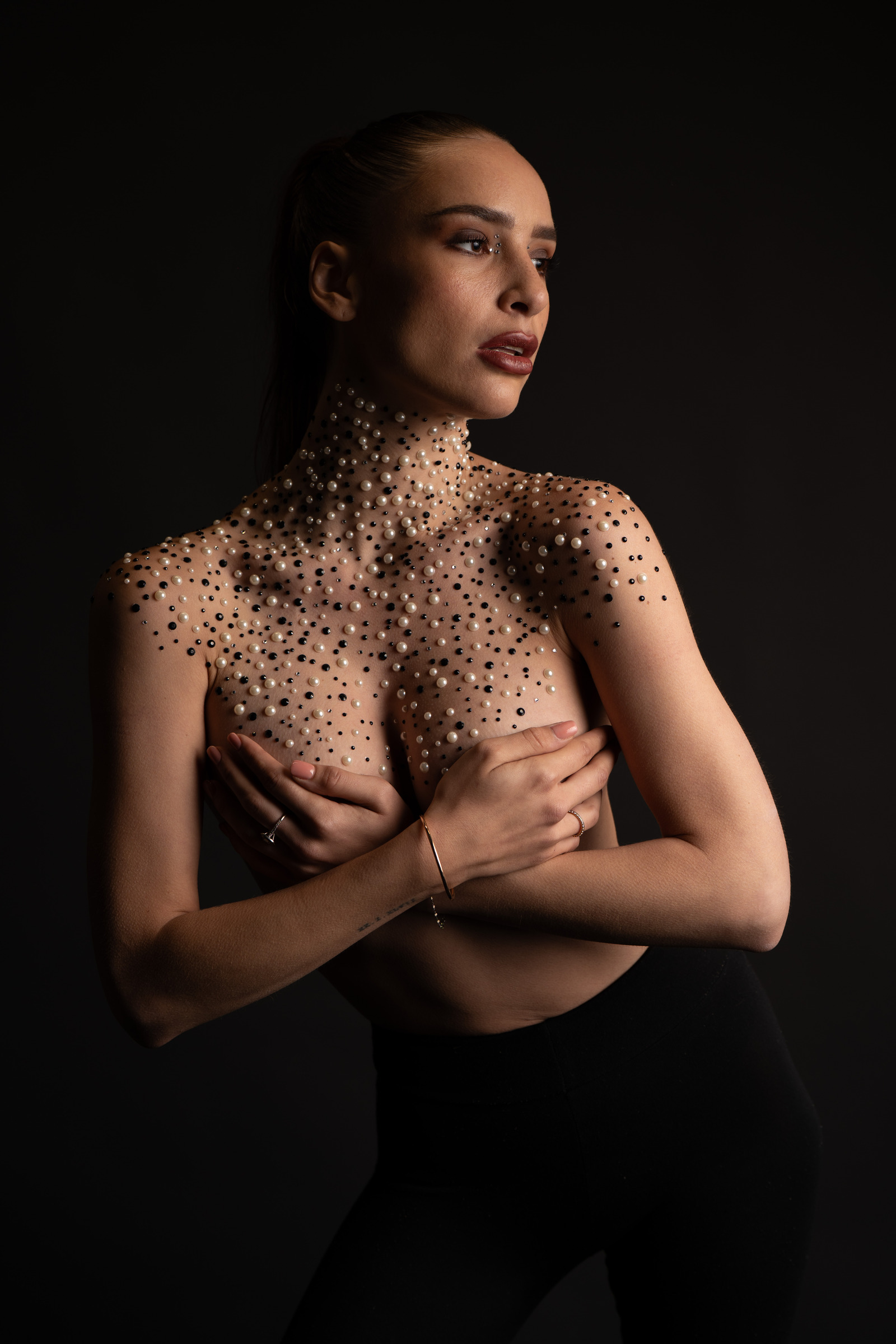 Portrait beauté sur fond noir, ornements dorés sur le buste
